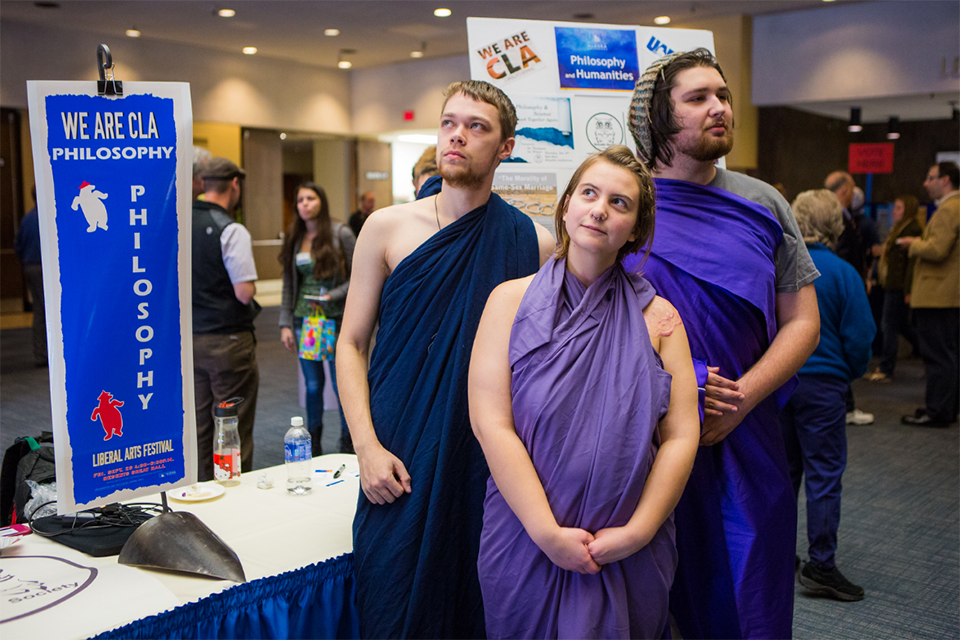 Three students in purple togas represent the philosophy program at the annual We Are CLA event. The College of Liberal Arts event, We Are CLA, celebrates the programs and departments offered on campus. | UAF Photo by JR Ancheta