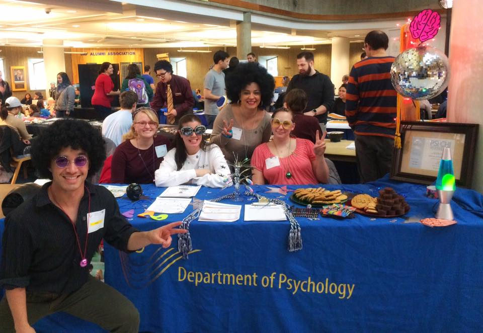 Faculty and students from Psi Chi, the psychology honors club, smile for the camera at a student club recruiting event