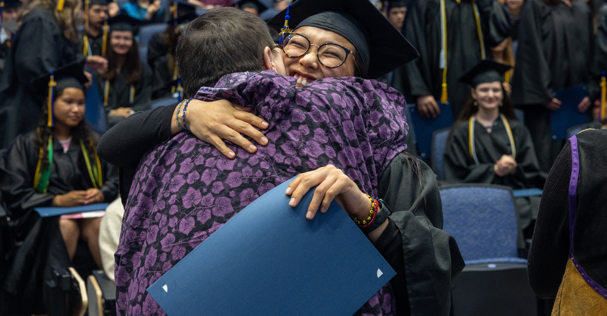 RAHI academic coordinator Debbie Mekiana and student Rhea Kanuk hug at 2025 RAHI Graduation