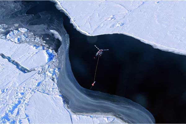 Aerial view looking down on a helicopter over the sea ice