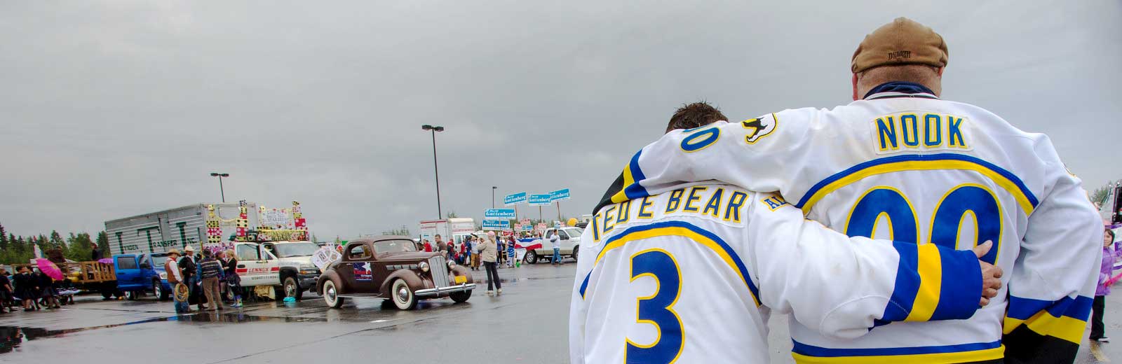 Two people in Alaska Nanooks hockey jerseys embrace at the annual Fairbanks Golden Days parade.
