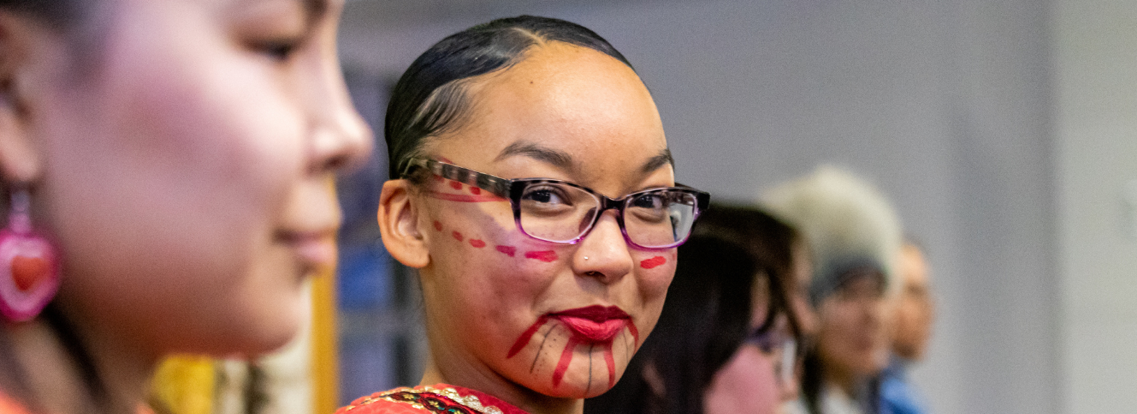 Dancer smiles at the Indigenous Peoples Day celebration.