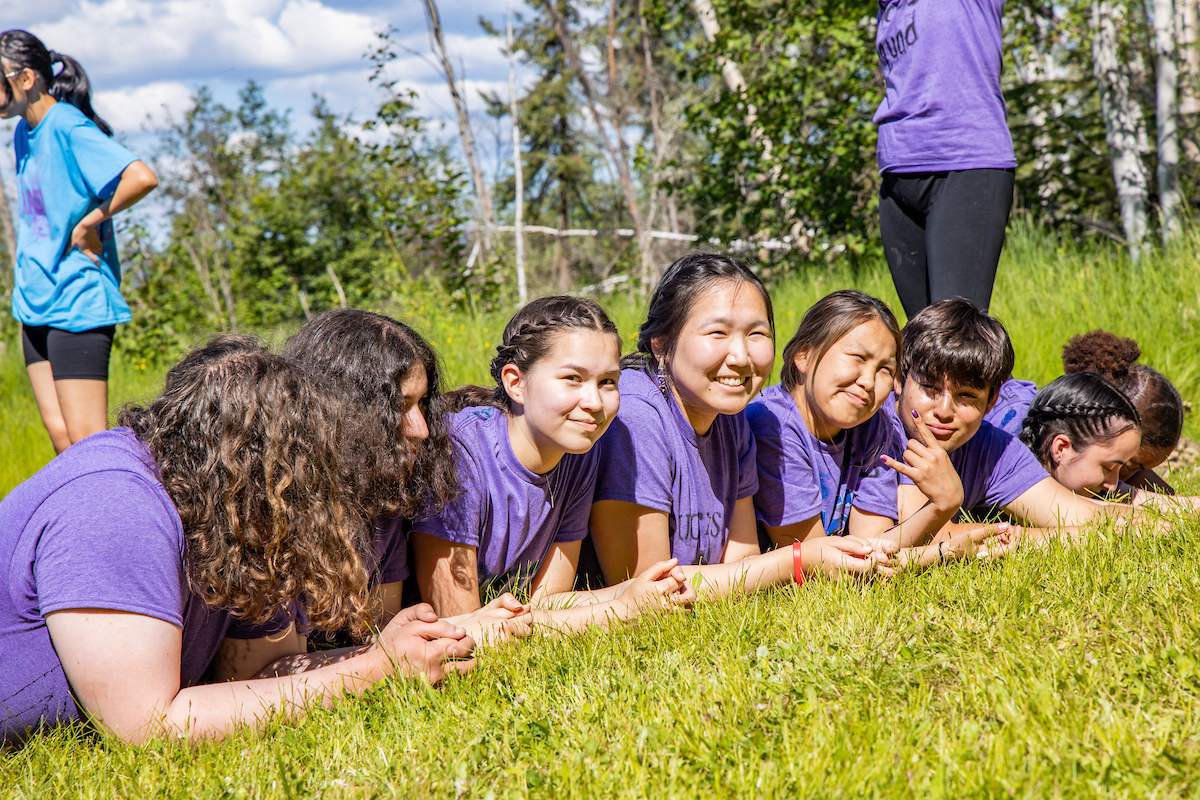 students laugh laying in the grass
