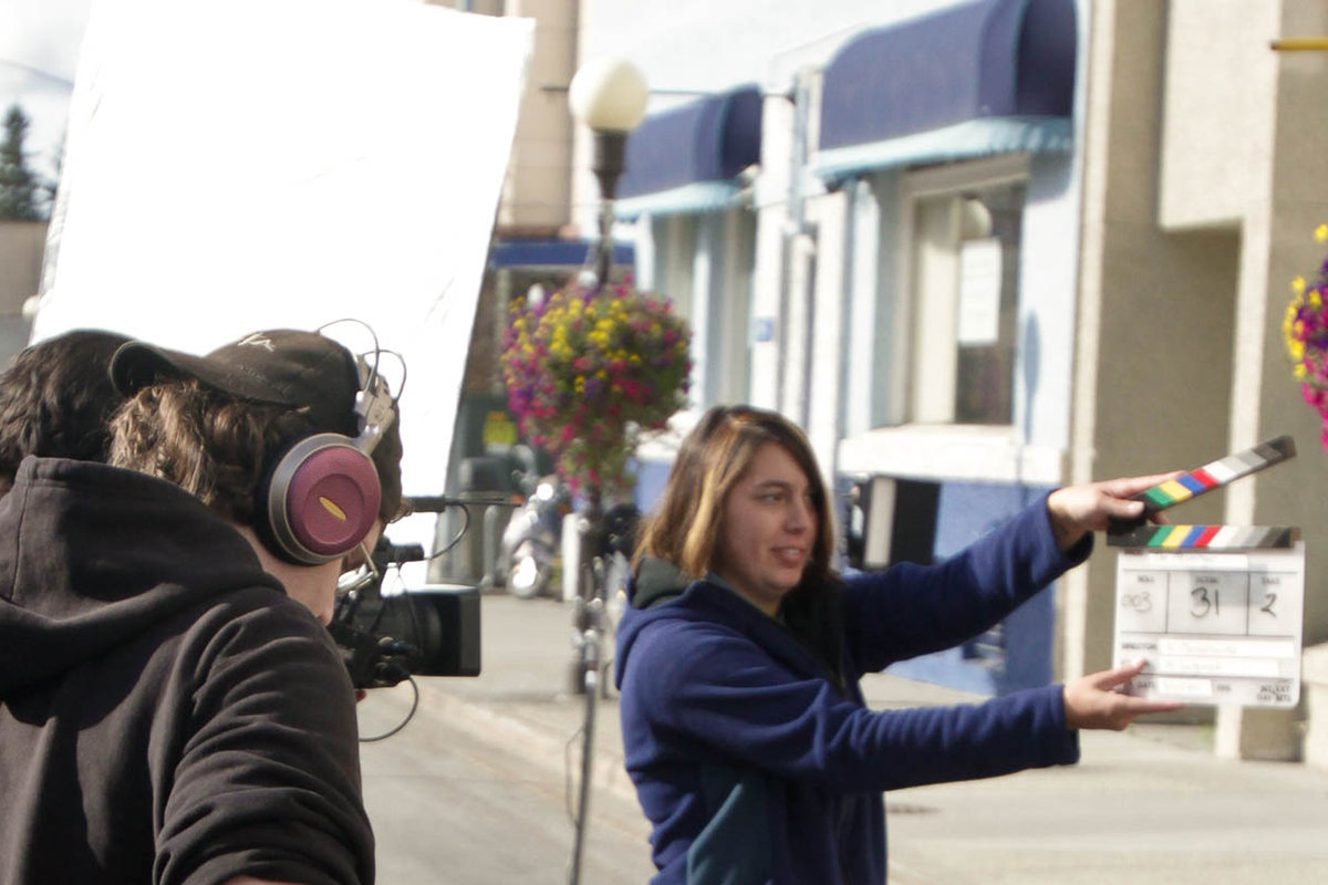 Behind the scenes of 'The Messenger,' the production crew prepares for shooting as Adrina Knutson holds the clapperboard to mark the beginning of the scene. Photo credit: UAF Department of Theatre and Film
