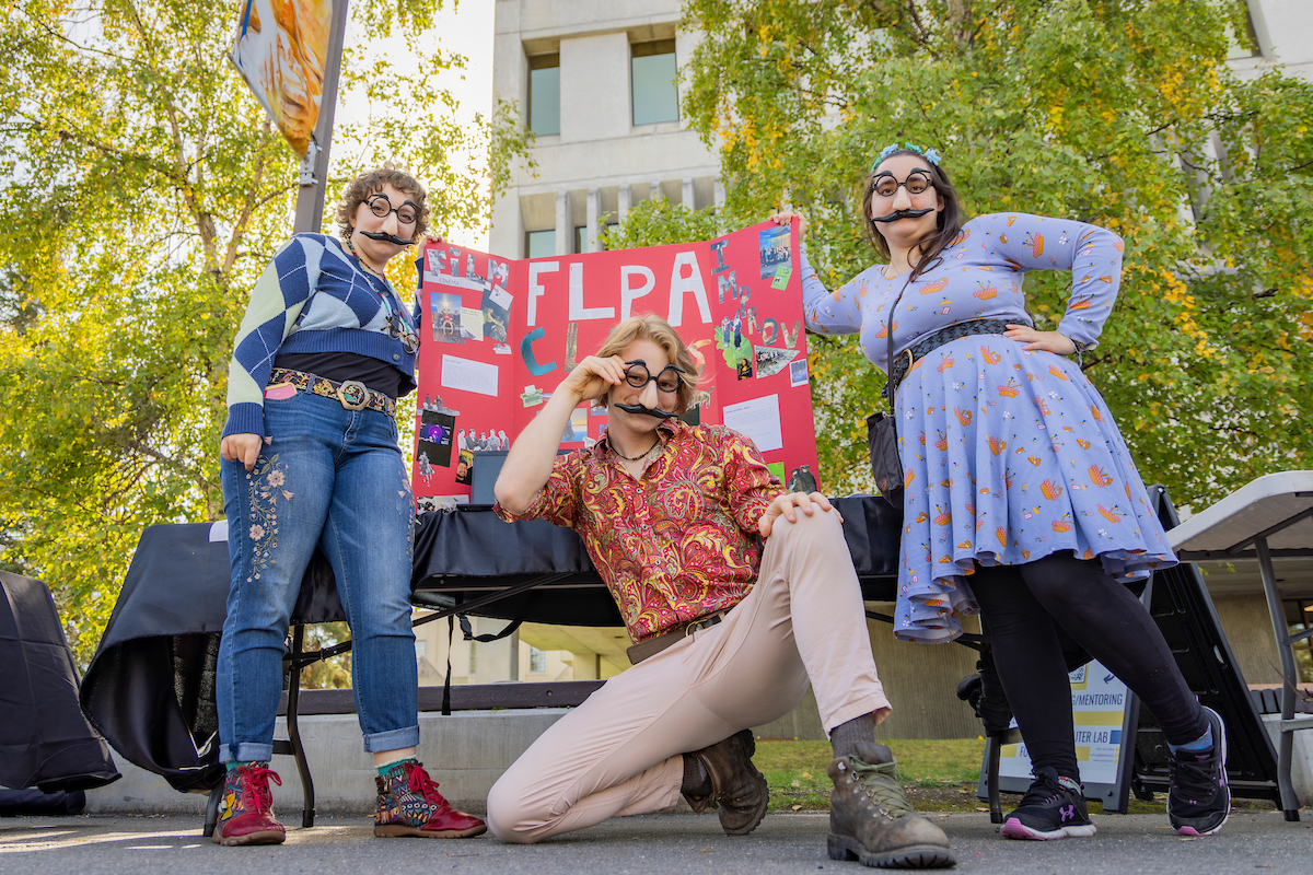 (left to right) Taylor Kamrath, Jesse Schnabel and Zorissa James of the FLPA Club take a photo together during Party in the Park on the lower Troth Yeddha' Campus, Sep. 3, 2024. (UAF photo by Leif Van Cise)