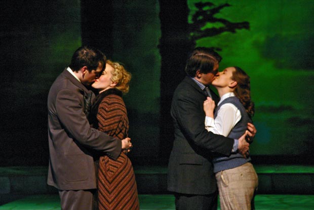 Love shines brightest under the spotlight: Two couples embrace, lost in kisses, center stage.