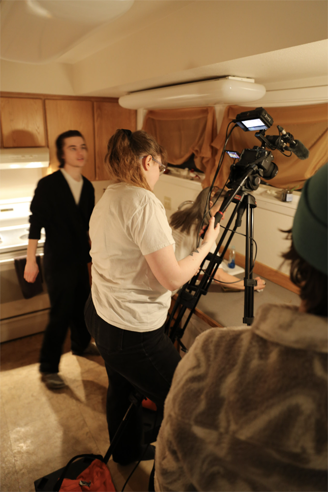 Strange Embrace BTS Crew set up a shot in the kitchen on the set of Strange Embrace. UAF Photo by Maya Salganek