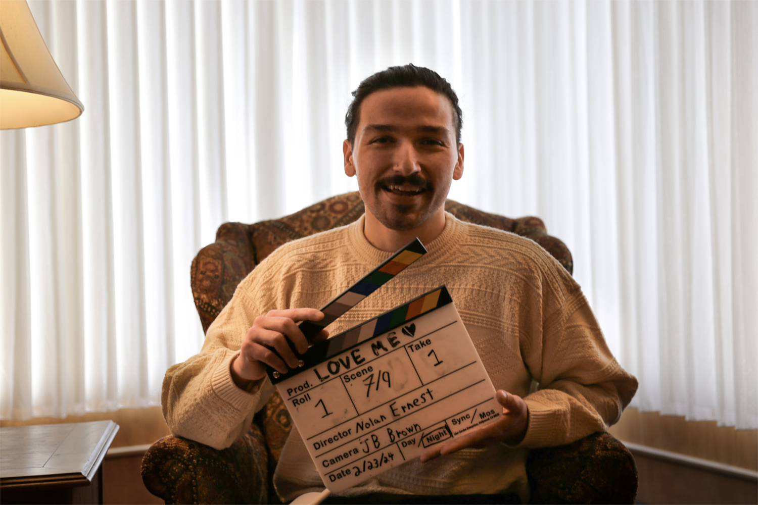 Strange Embrace BTS Cast from Strange Embrace holding a clapperboard prepares for filming. UAF Photo by Maya Salganek