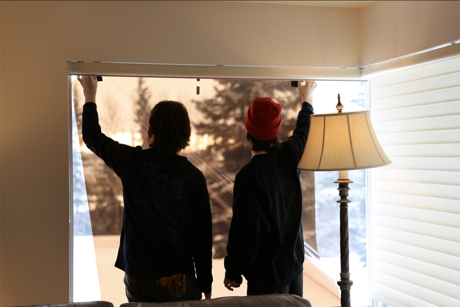 Strange Embrace BTA Putting a film over the windows to control the light on the set of Strange Embrace. UAF Photo by Maya Salganek