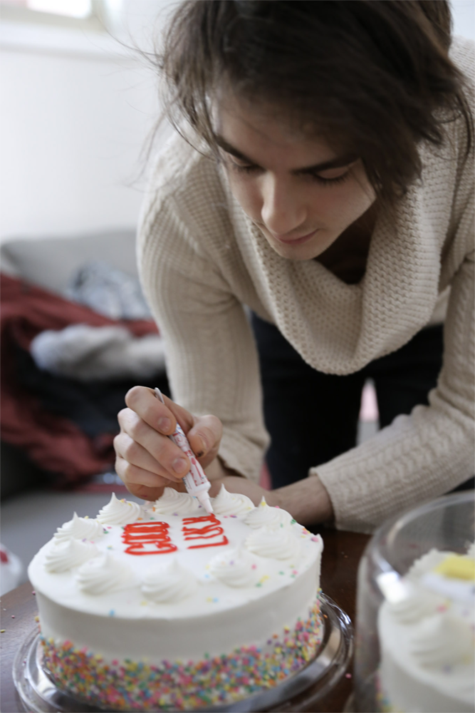 Strange Embrace BTS Cast member Seamus Knight decorates a prop cake for the film Strange Embrace. UAF Photo by Maya Salganek