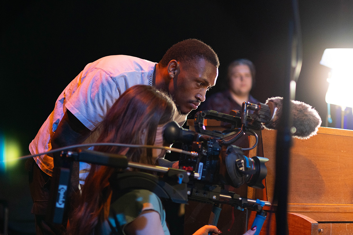 TAOS, Day 1, image 33 Dre Williams and Chloe Miller run the camera filming an actress playing the piano on stage. Photo credit: Eric Marshall