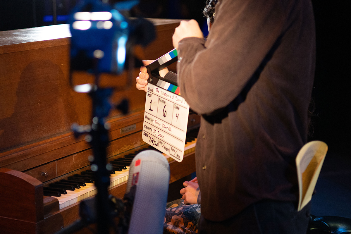 TAOS, Day 1, image 49 Crew members with a clapperboard in front of a piano. Photo credit: Eric Marshall