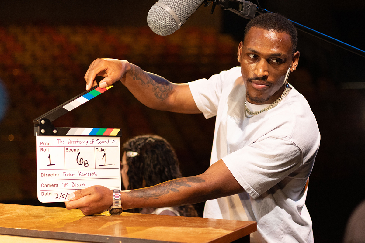 TOAS, Day 1, image 92 Dre Williams holds a clapperboard over a piano, ready to mark the start of filming. Photo credit: Eric Marshall