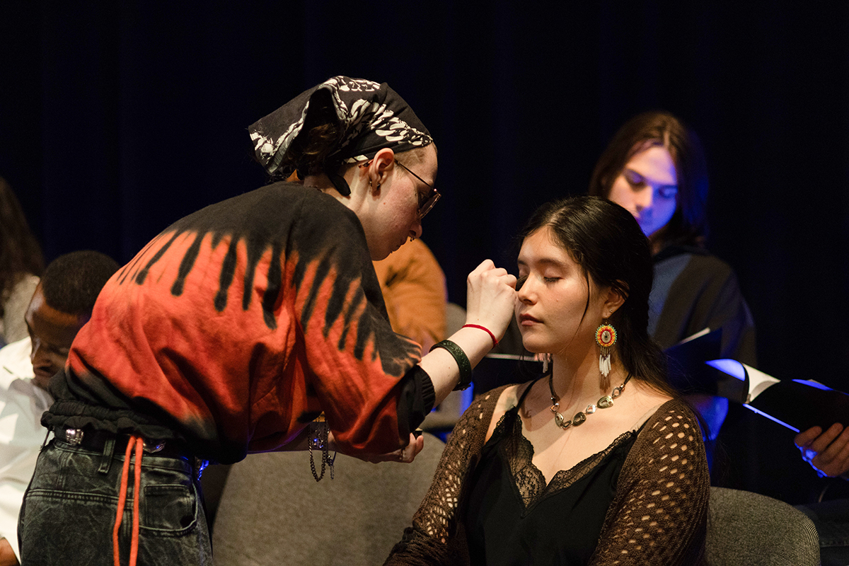 TAOS, Day 2, image 119 Fritz Lutrell applies makeup to Na’ni’eezh Peter during a quick break in filming. Photo credit: Eric Marshall