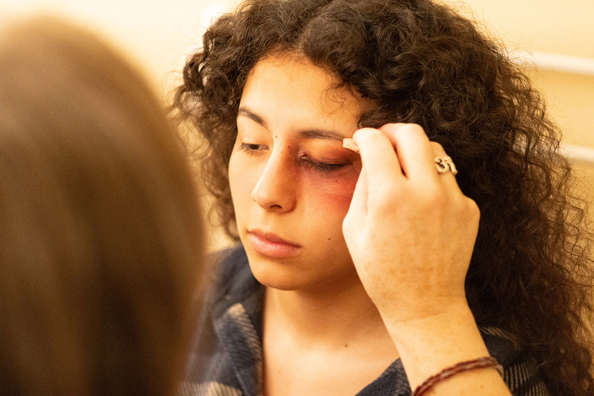 TAOS, Day 5, image 10 Makeup is applied to Julieth Harvey to give the appearance of a black eye. Photo credit: Eric Marshall