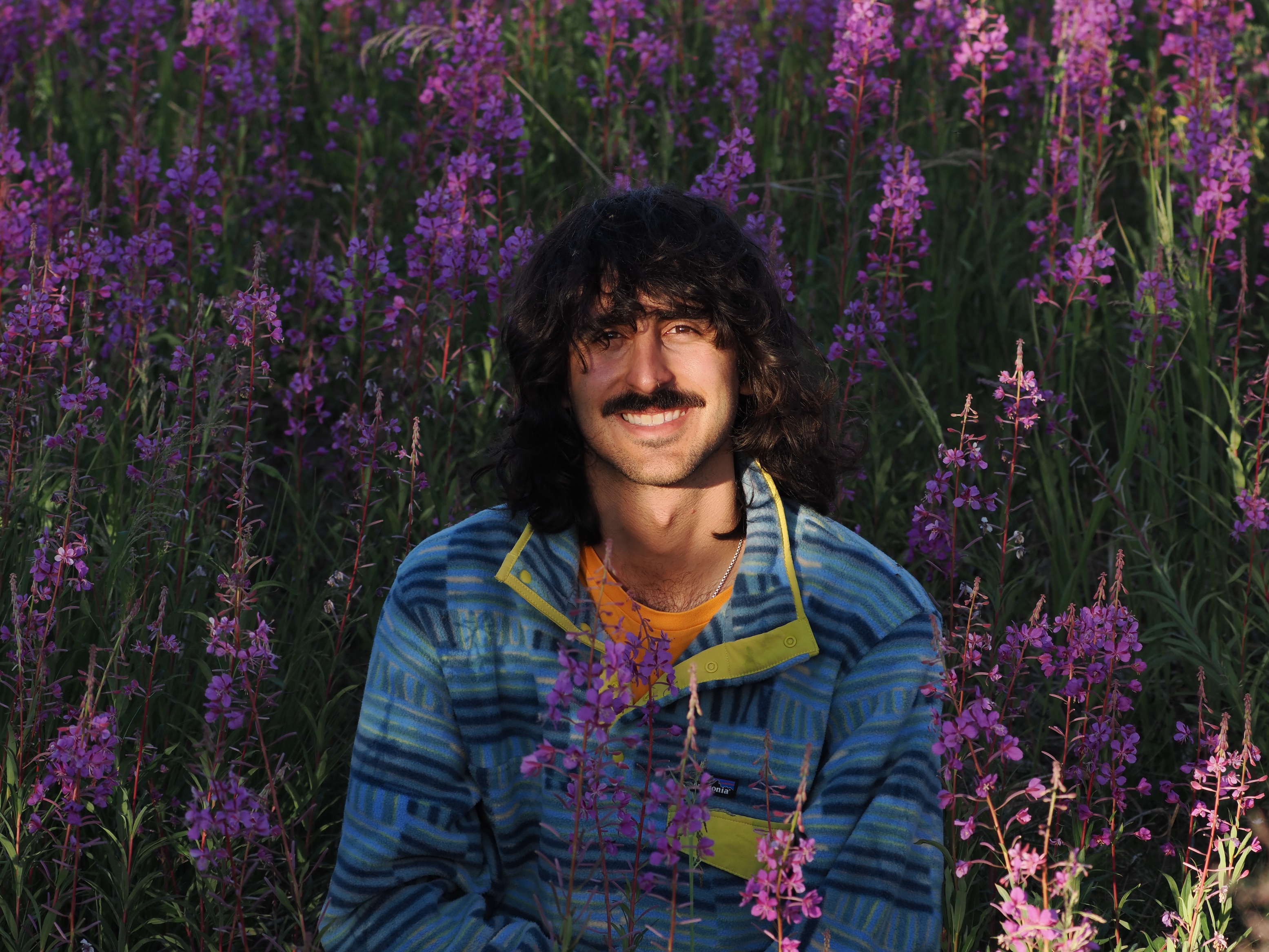 Jonathan Carcache surrounding by blooming fireweed