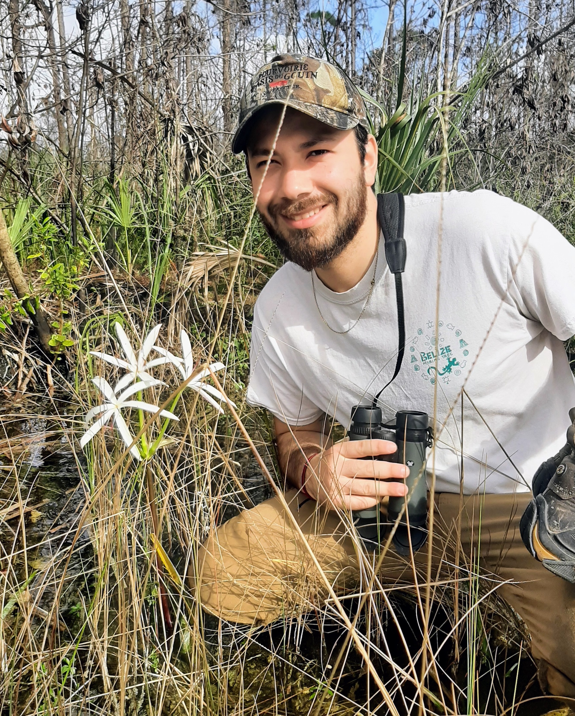 Joseph Molina poses by a flower in the field
