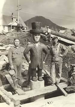 Tlingit men stand next to a carved figure of Lincoln near Ketchikan