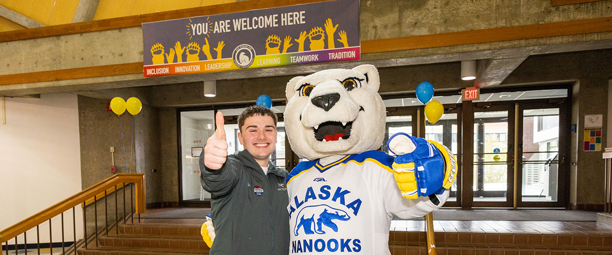 A UAF student poses with the Nook mascot inside the Wood Center student union on the Fairbanks Troth Yeddha campus.