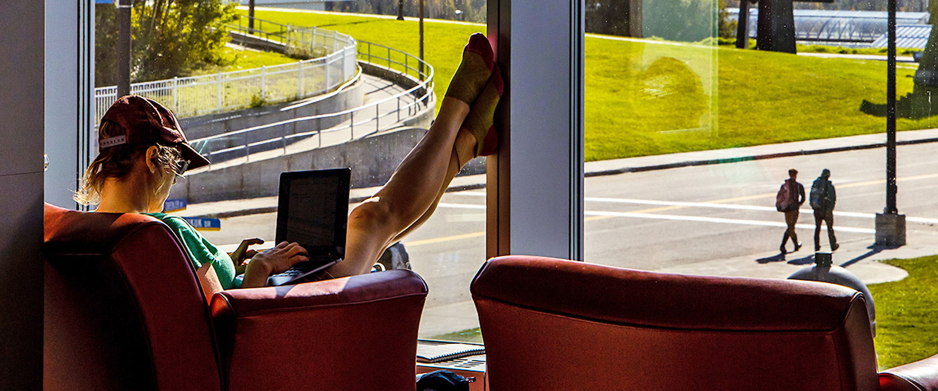 A student with a laptop studies in the lounge of the Murie building.