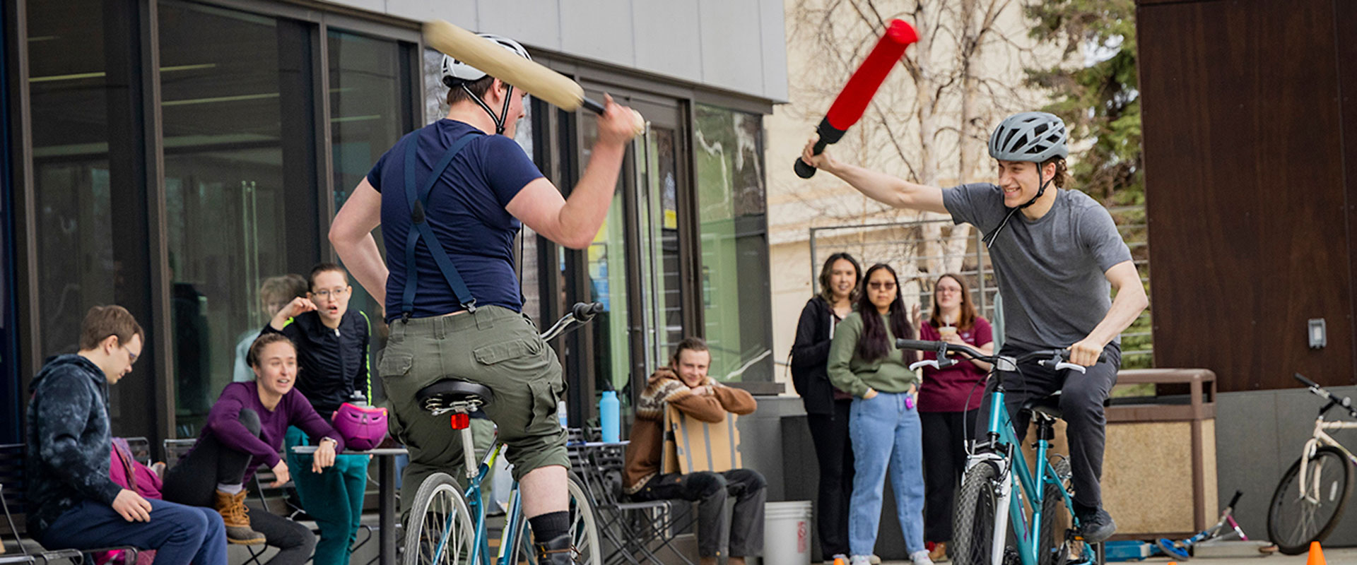 Students participate in a bike jousting activity outside the Wood Center during SpringFest.