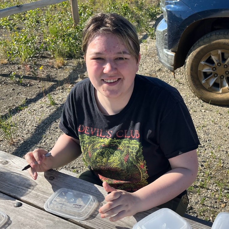 Jessie sitting at a picnic table with supplies in front of them.