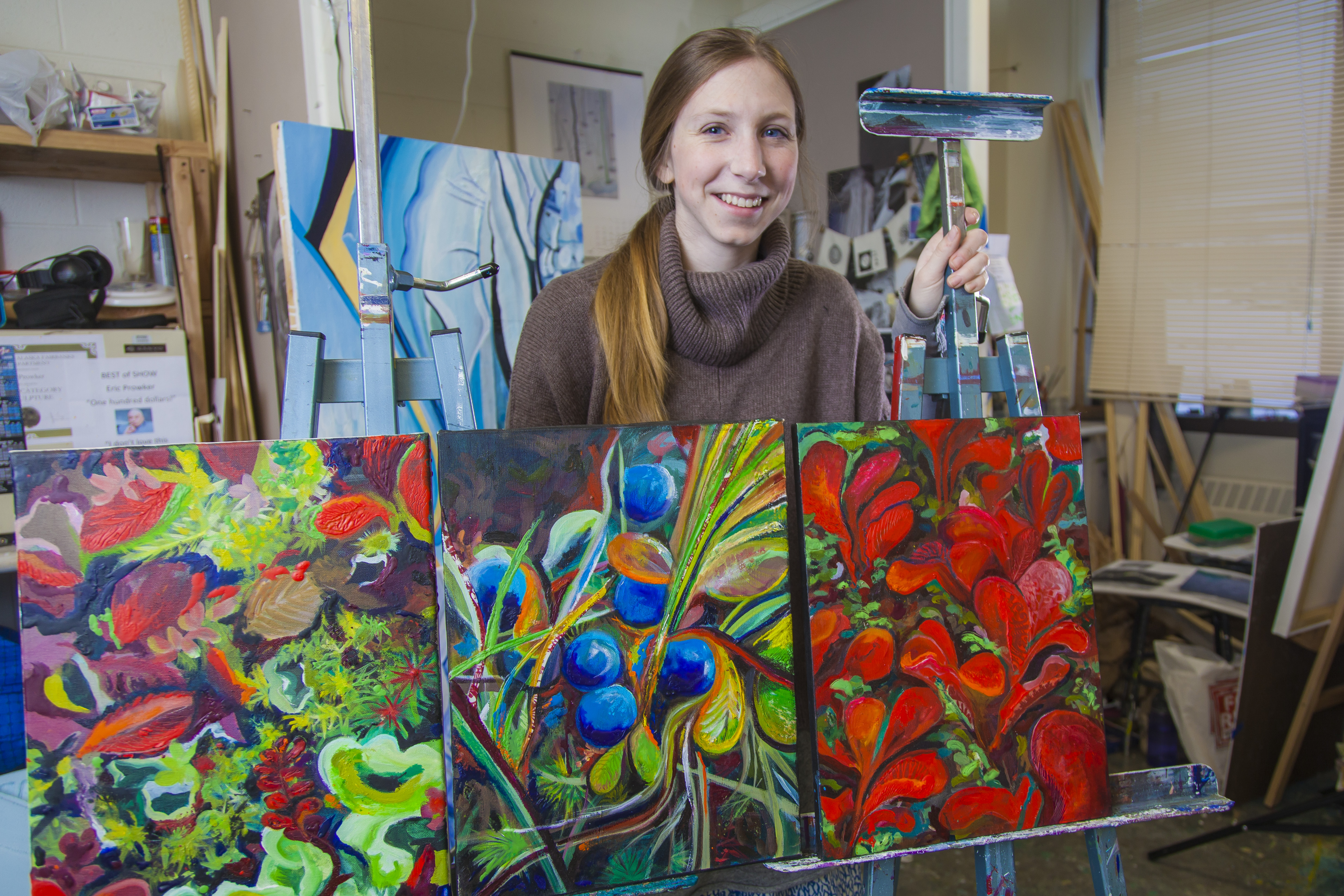 Student displaying their paintings