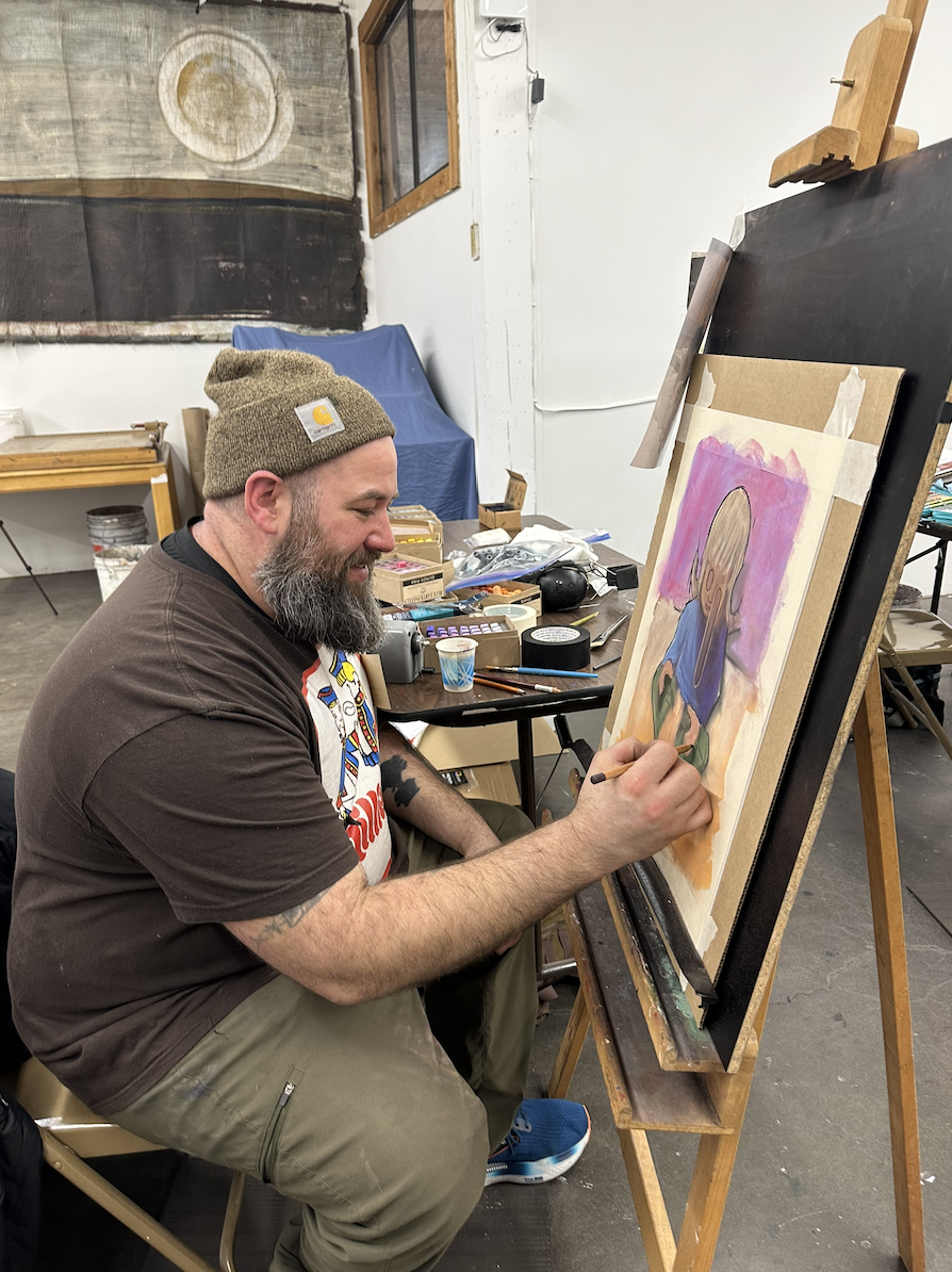 Kevin sits at an easel with pastel artwork in progress