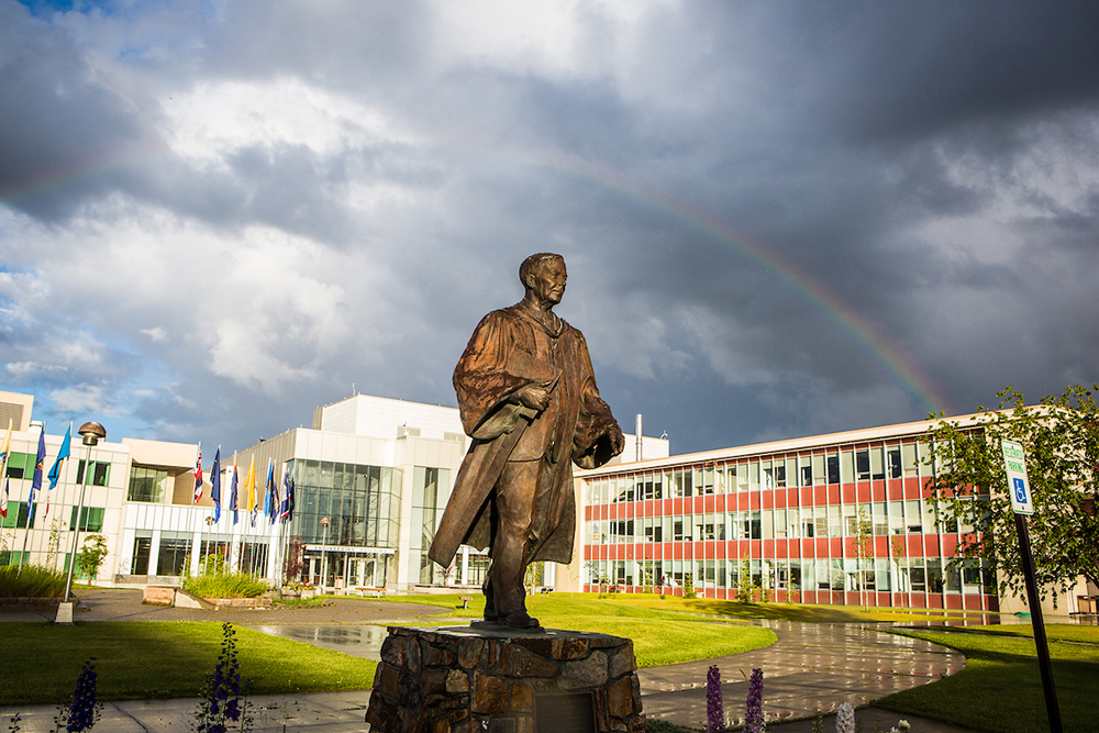A rainbow appears over the Charles Bunnell statue on the Fairbanks campus during an evening shower at the start of the Fourth of July weekend. | UAF Photo by JR Ancheta